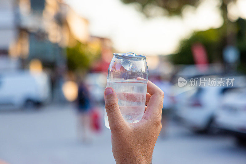 不认识的女人拿着装着水的塑料罐