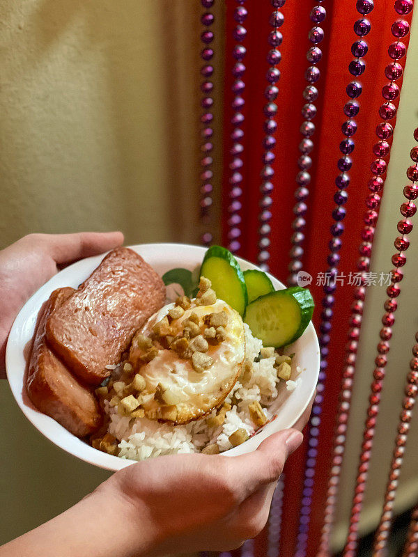 中国传统的一碗米饭，上面有午餐肉和鸡蛋