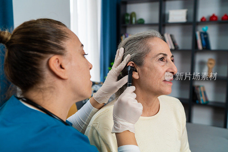医生检查老年女性患者的耳朵