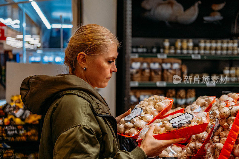 在市场上买蘑菇的女人
