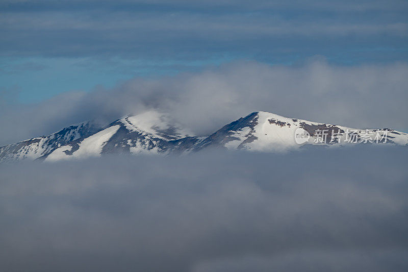 美国西部、北美的黄石生态系统中，云层之上的雪峰的山景