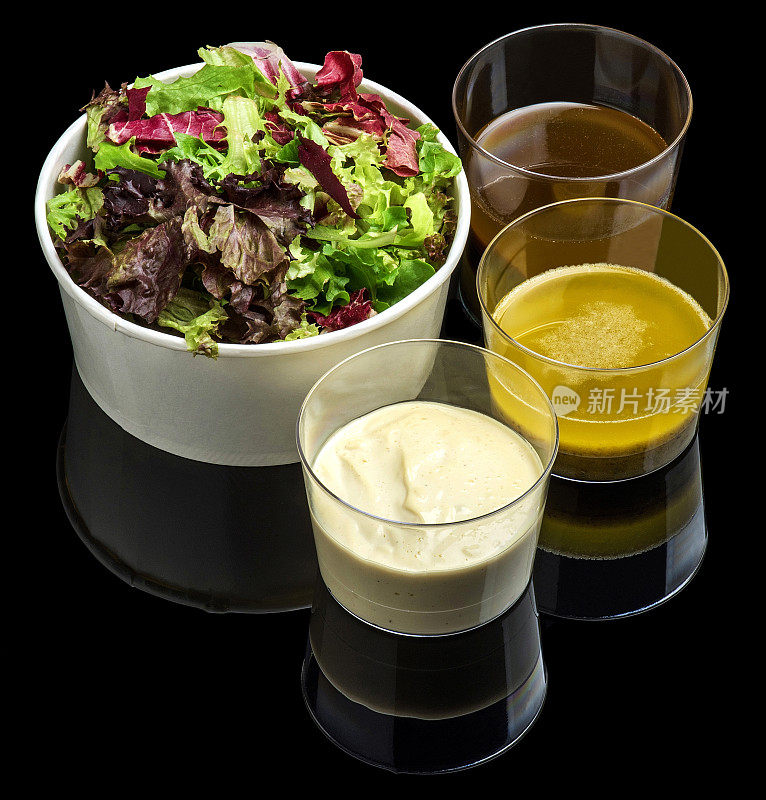 混合蔬菜沙拉和酱汁在黑色玻璃背景