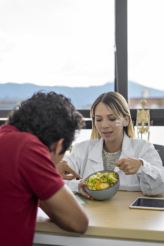 营养学家为病人提供蔬菜沙拉健康饮食咨询。健康饮食计划及适当营养的概念。