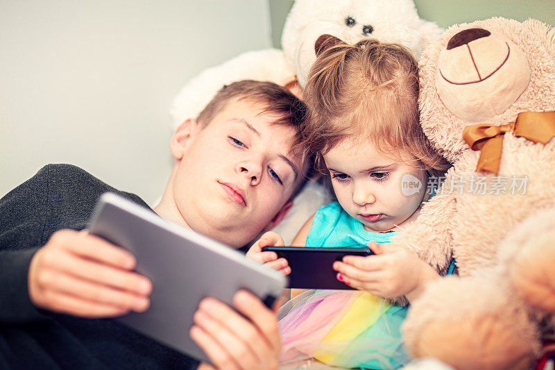 小孩子使用数码平板电脑和智能手机