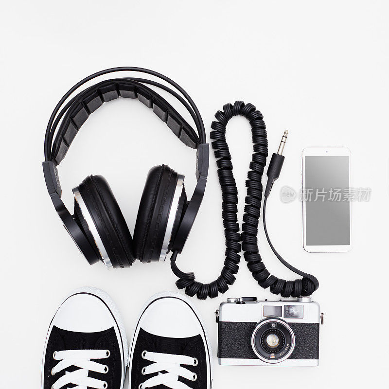 音乐和摄影。潮人的物品。单反胶片相机，智能手机，运动鞋和白色背景的音乐耳机