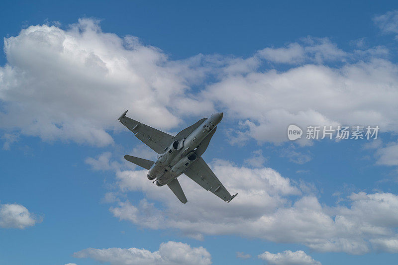 F-18超级大黄蜂战斗机在蓝天白云的映衬下飞翔