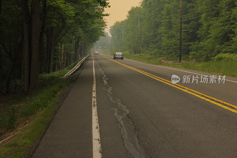 在宾夕法尼亚州波科诺斯阿巴拉契亚山脉吉姆索普的乡村地区，通往地平线的废弃高速公路下的火灾烟雾