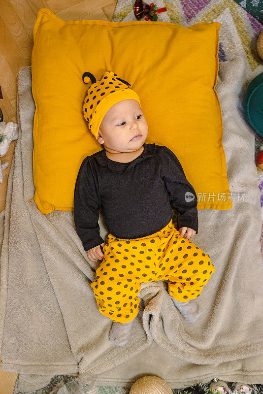 可爱的婴儿躺在黄色的枕头上
