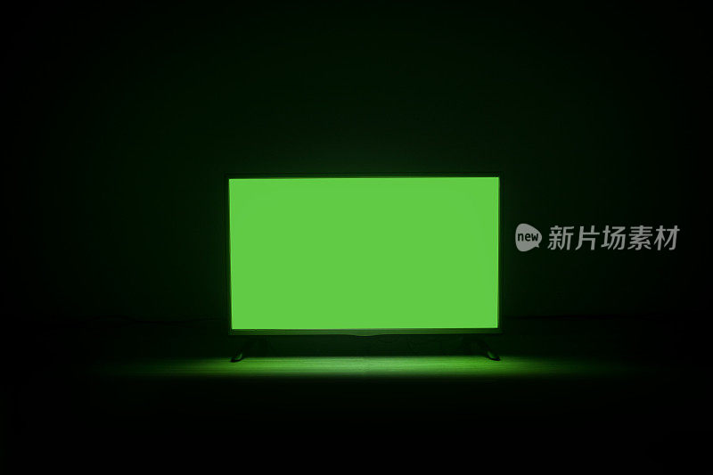 4K液晶电视切色度键绿屏在暗背景地板上。