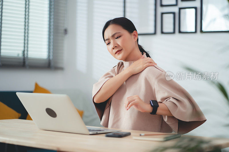 患有办公室综合症的亚洲女性坐在家里办公。