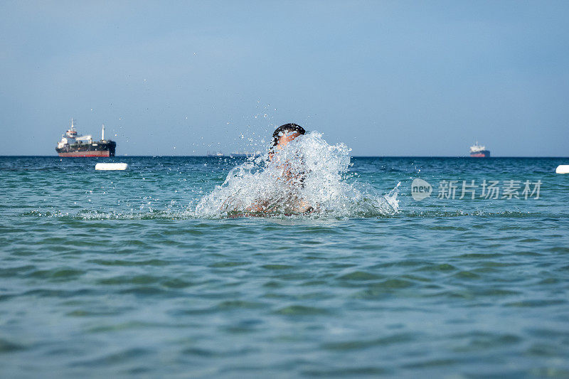 他用手在海里泼水。一个夏天的早晨。忒涅多斯岛。爱琴海北部，12岁的帅哥。长头发的