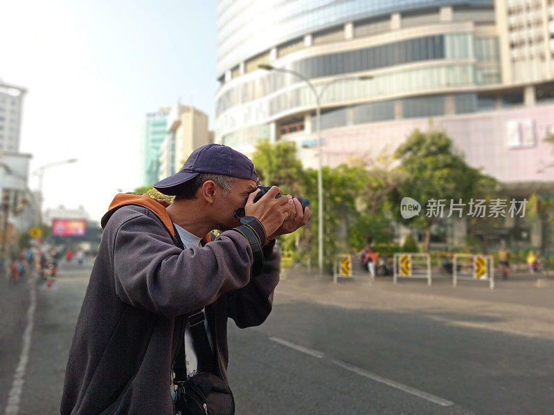 摄影师正在城市街道上做他的日常工作。