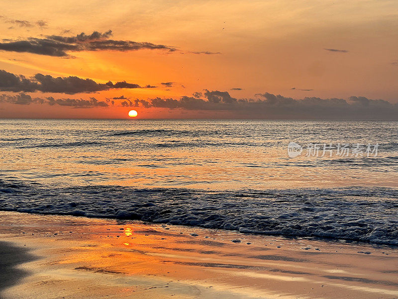 佛罗里达的日落在宁静的水面上，在印第安岩石海滩上，太阳在水中反射