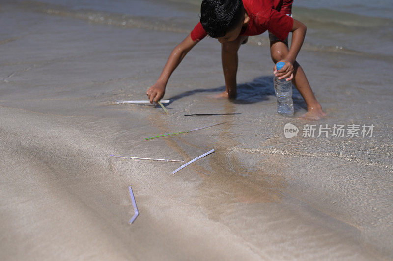 在海滩捡塑料吸管