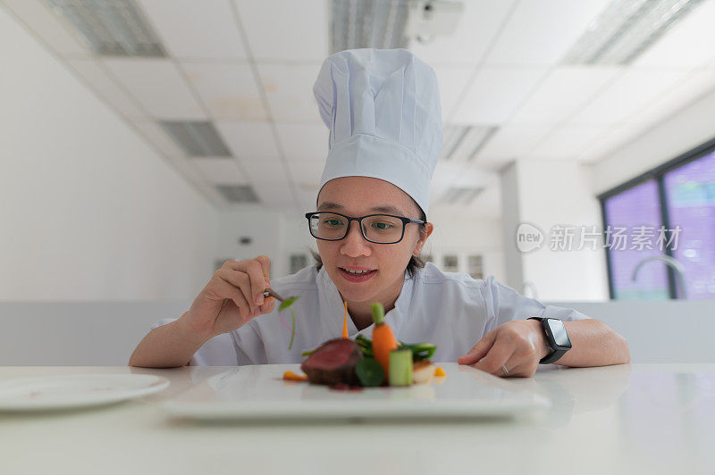 亚洲女厨房学徒装饰食物