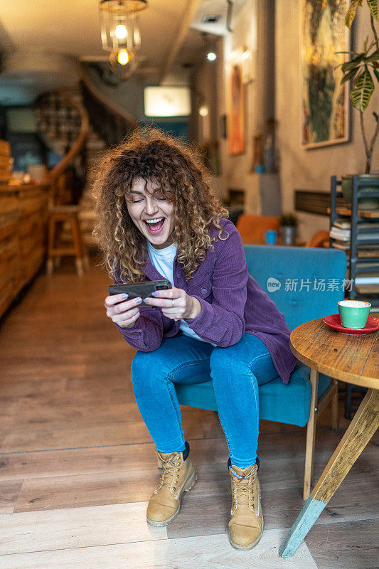 在智能手机上玩电子游戏的快乐女人