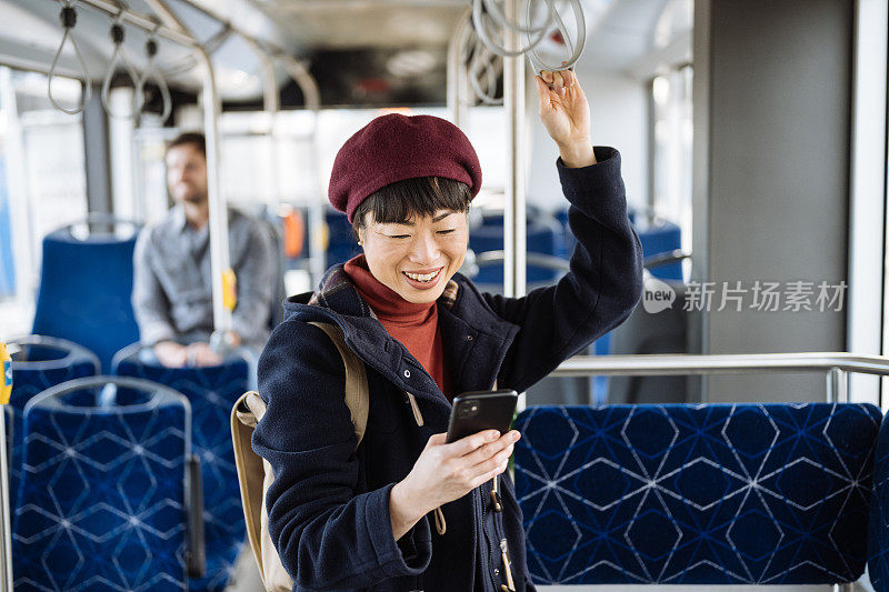 成熟的日本女性在城市里乘公交车上下班。亚洲女性正在使用智能手机