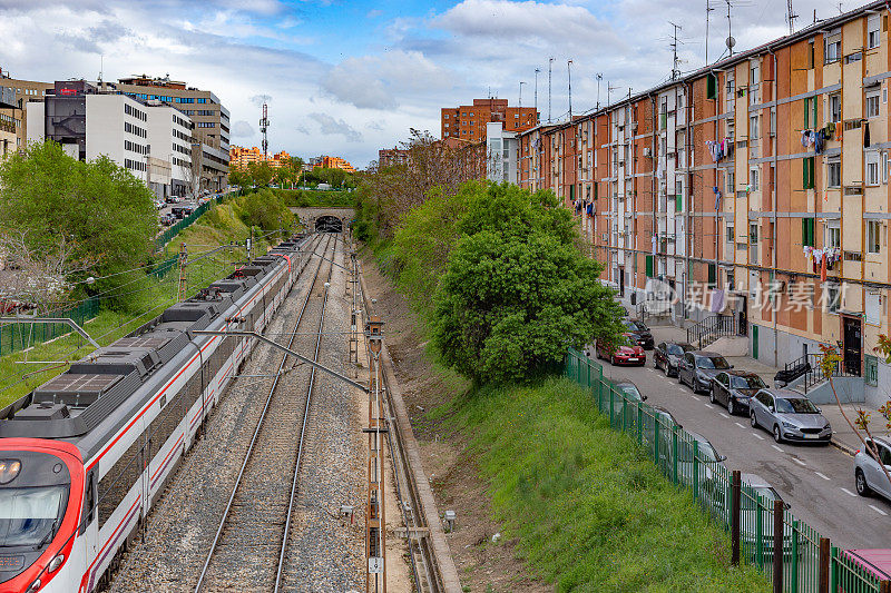 火车轨道上的人行天桥穿过郊区社区的高架视图。