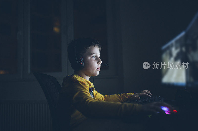 小男孩在家里玩电脑游戏