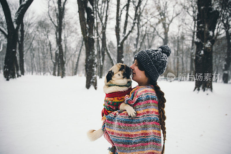 女人和狗在冬季假期享受雪