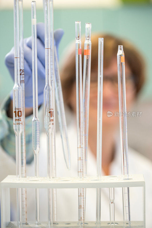 女性研究员在实验室拿起移液管