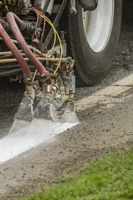 特写商业卡车重新油漆道路标记在农村道路。