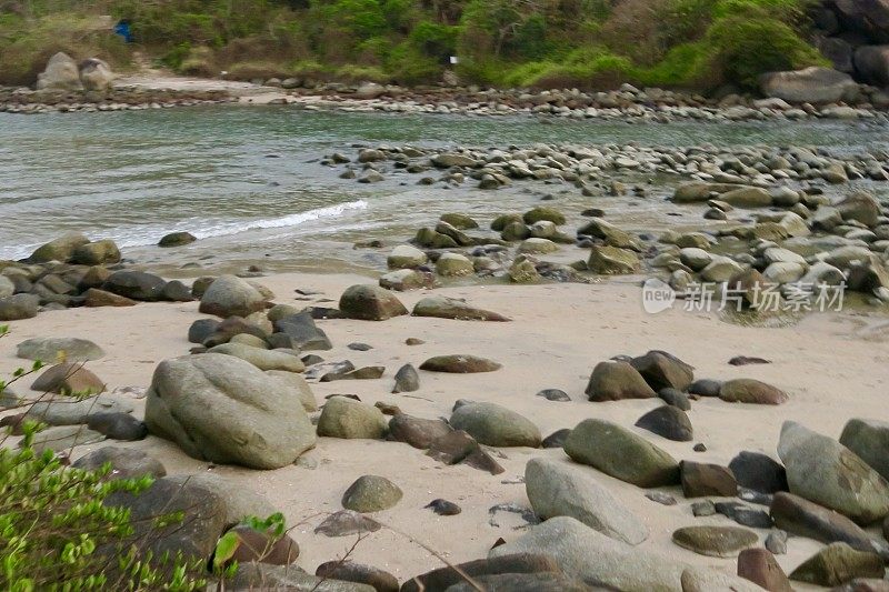 图片中的印度热带岛屿天堂海滩度假，金色的沙子，蓝色的大海，光滑的鹅卵石和经过侵蚀的灰色岩石，椰子树，帕洛伦海滩，果阿，印度南部