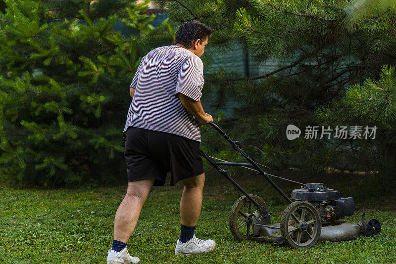 拿着割草机的人