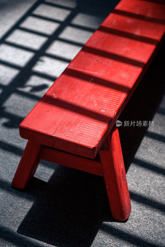 阴影在红色的木凳上