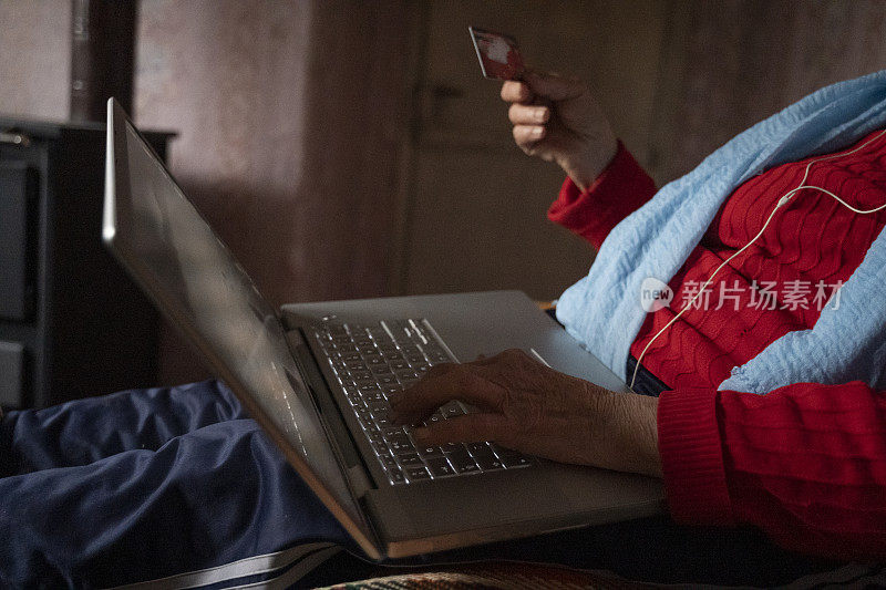银色冲浪者。有魅力的活跃的老年妇女与她的孩子在网上聊天，使用她的笔记本电脑。在网上冲浪时有乐趣。