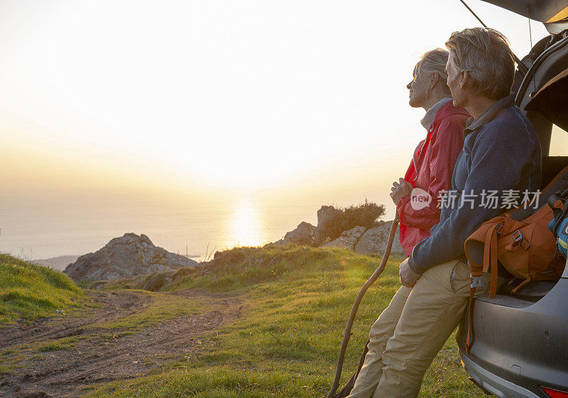 徒步旅行的夫妇在远足后停在汽车后挡板上