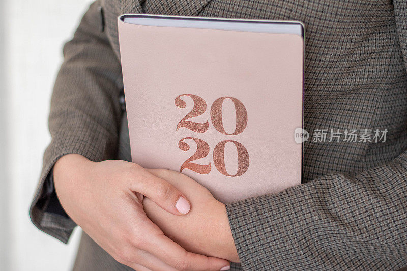 手握2020计划书的特写。制定2020年的新计划