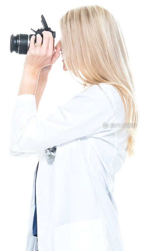 白人年轻女性游客站在白色背景前穿着实验服，拿着相机