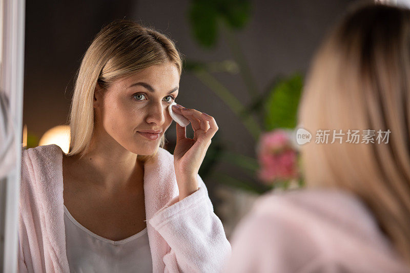 一个女人在镜子前洗脸