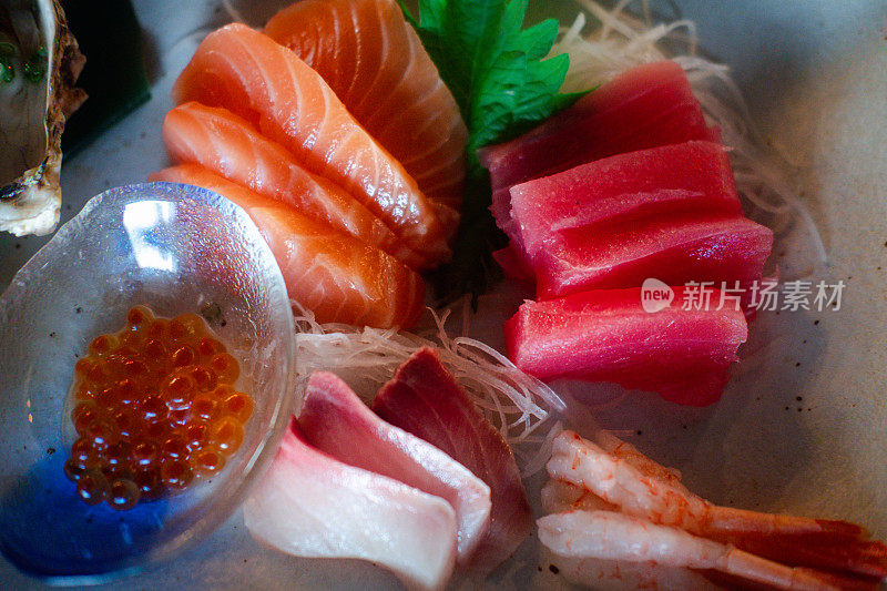 三文鱼籽配鲜鱼生鱼片，色彩斑斓，美味可口。日本料理生鱼片套装