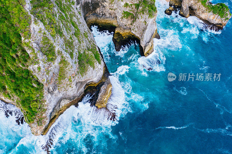 蓝色的海洋和被热带植物覆盖的悬崖。从上面看巴厘岛海岸。空中无人机拍摄。