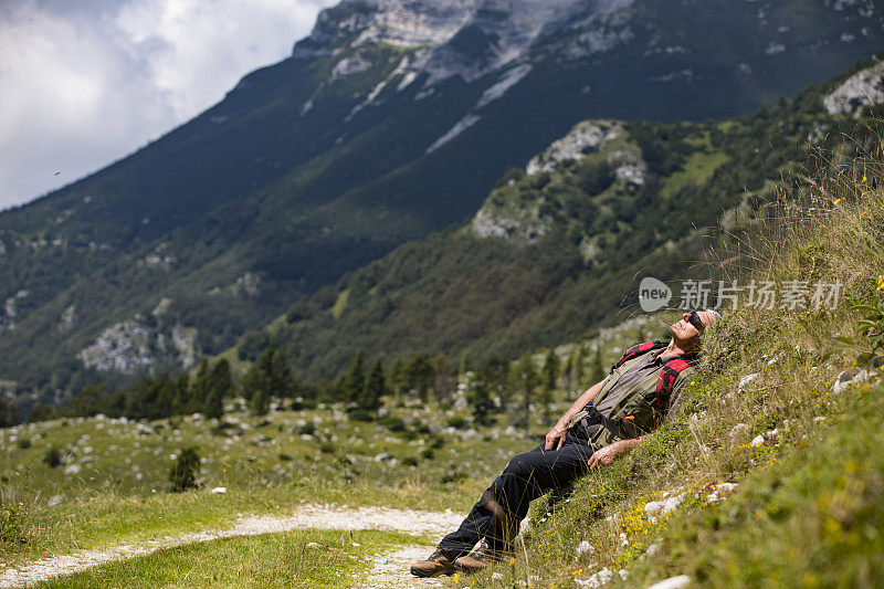 活跃的老年人在山间徒步旅行中放松