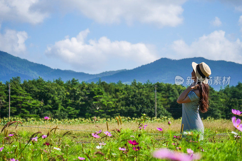 美丽的年轻女子在花圃休息