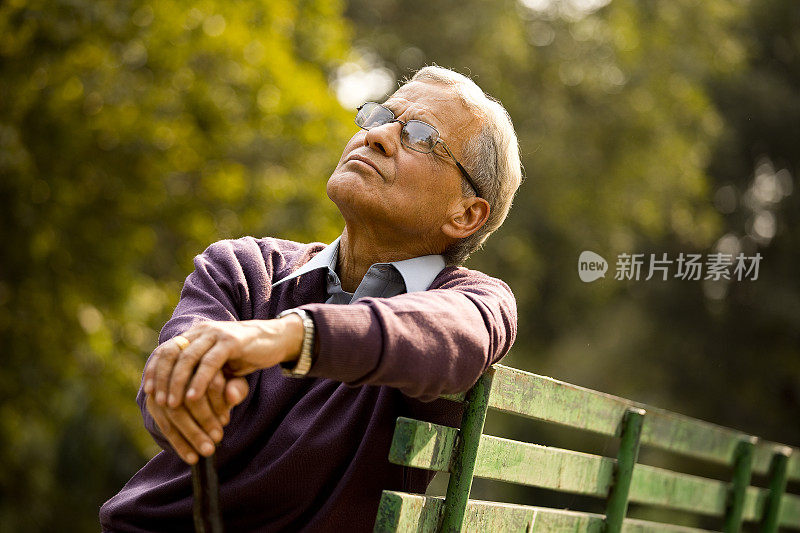 坐在公园里的深思熟虑的老人