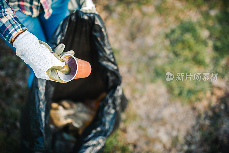 不认识的女人捡塑料垃圾。