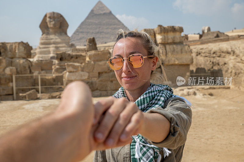 一对夫妇在埃及旅行，他们手牵着手跟随对方