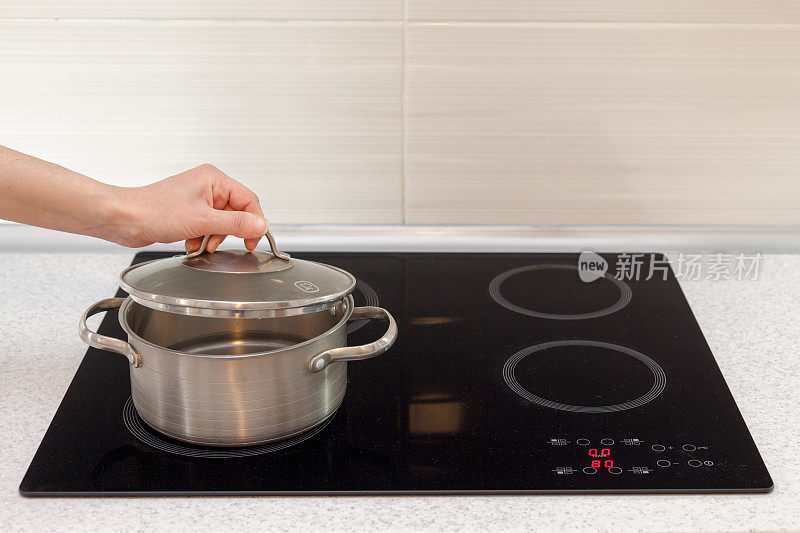 现代厨房里，女人用手打开平底锅