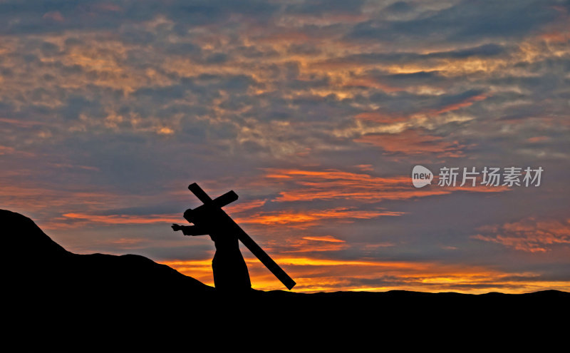 耶稣基督背着十字架的剪影日落