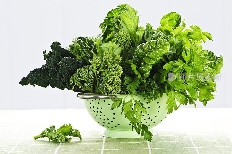 不锈钢滤锅里装着不同种类的绿色蔬菜