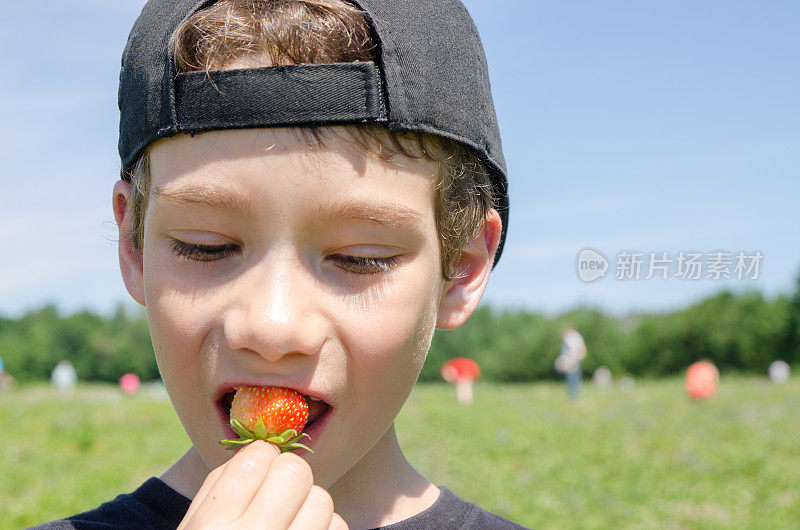 小男孩在外面吃草莓的特写