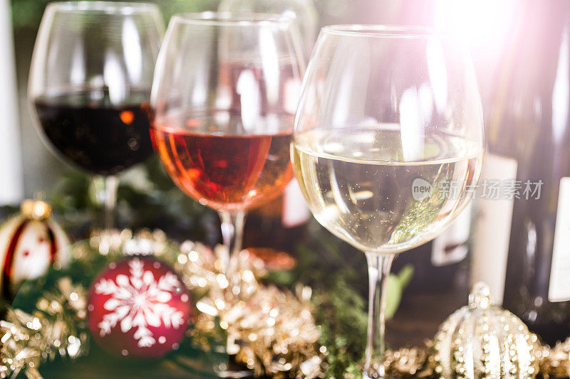 圣诞节餐桌上的酒杯里盛着各种各样的葡萄酒。