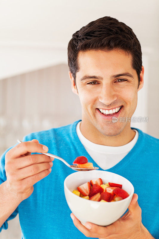 快乐的人正在吃一碗水果沙拉