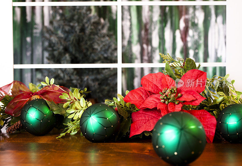 窗边餐桌上的一品红和圣诞树饰品。