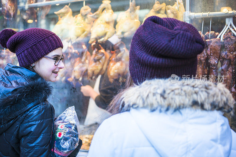 曼哈顿唐人街，女孩们在橱窗里看中国菜