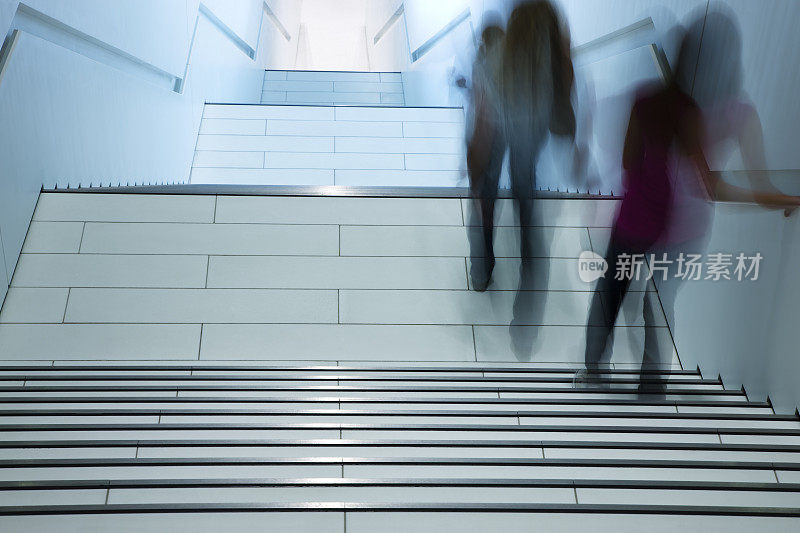 女性在现代室内走下楼梯，动态模糊